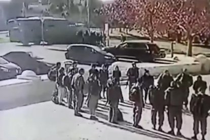 Autoritats i forces de seguretat davant del camió amb el frontal tirotejat.