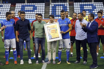 Toni i Joan Vicente, els fills d’Emili, posen al costat de la seua mare, Antònia Armengol, que va entregar el trofeu de campió a Joan, com a capità del Lleida.
