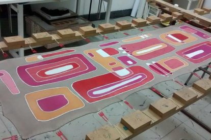 Una peça de seda a la qual falten alguns retocs, al bastidor.