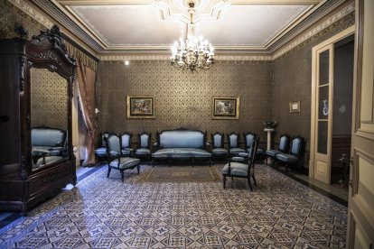 Un dels salons de la casa senyorial Duran i Sanpere de Cervera i, a la dreta, la capella privada de l’edifici, amb els personatges de les pintures inspirats en la mateixa família.