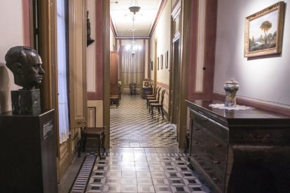 Un dels salons de la casa senyorial Duran i Sanpere de Cervera i, a la dreta, la capella privada de l’edifici, amb els personatges de les pintures inspirats en la mateixa família.