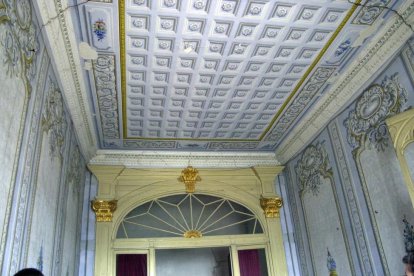 Un dels salons de la casa senyorial Duran i Sanpere de Cervera i, a la dreta, la capella privada de l’edifici, amb els personatges de les pintures inspirats en la mateixa família.