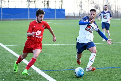 Un jugador de l’Alpicat s’escapa amb la pilota als peus davant de la persecució d’un jugador local.