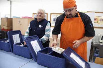 Miquel Àngel y Francisca de Alba entregando la comida a Josep de 86 años y que vive solo.