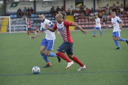 Un jugador del Mollerussa intenta controlar una pilota de cap davant de l’oposició d’un rival del Balaguer.