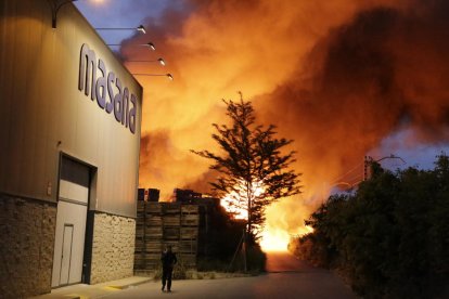 Un espectacular incendi calcina palots i una nau al polígon i talla la via del tren
