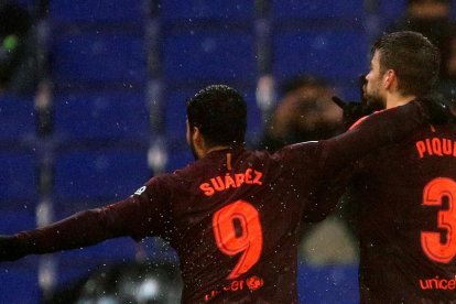 Luis Suárez controla el balón junto a Aarón Martín, del Espanyol.