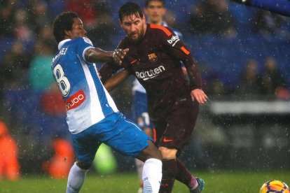 Luis Suárez controla el balón junto a Aarón Martín, del Espanyol.