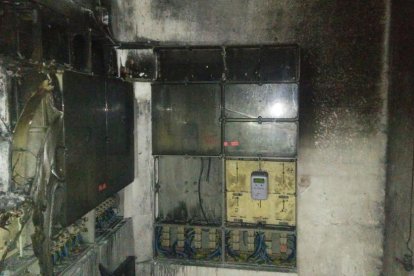 Un grupo de vecinos del inmueble en uno de los pasillos del edificio, todo el piso está sin luz ni agua.