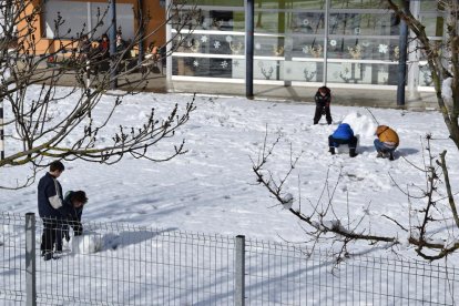 Un operario de Endesa accediendo a una línea en Ribera d’Urgellet (izquierda) y niños en la escuela sin luz de El Pla de Sant Tirs (derecha).