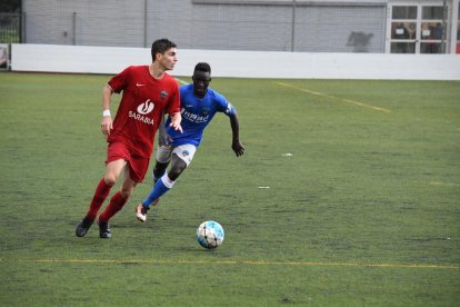 Un jugador de l’Alpicat intenta controlar una pilota davant de l’oposició d’un rival del Lleida B.