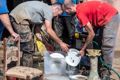 Voluntaris mallorquins donant un cop de mà en l’extracció de llot a la localitat afectada, ahir.