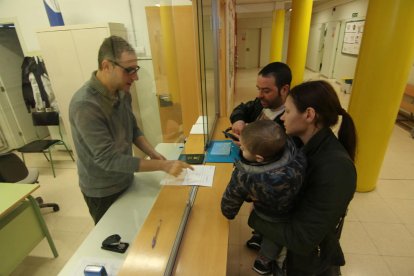 Unos padres llenan la solicitud de la preinscripción en el colegio Riu Segre.