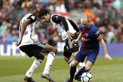 Iniesta s’emporta la pilota davant de Gayá i Gabriel Paulista.