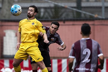 Un jugador del Júpiter i un altre del Tàrrega pugnen per la pilota durant una acció del partit.
