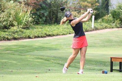 Ares Boira, tercera por la derecha, junto a su entrenador y sus compañeras del equipo. Derecha, haciendo el swing al golpear la bola.