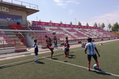 Jugadors, entrenadors i familiars de l’FC Madràs al costat de tècnics lleidatans, entre els quals Fede Bessone, dijous a l’Atlètic Segre.