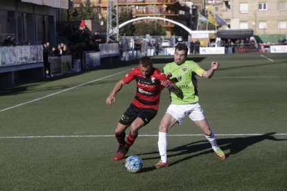 El jugador visitante Fabregat se eleva por encima del resto para despejar de cabeza, ante la presencia de Traguany y del local Jordi Martí.