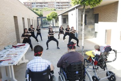 Un estudiant d’Educació Social dona a provar guacamole mexicà a una resident d’Aremi.