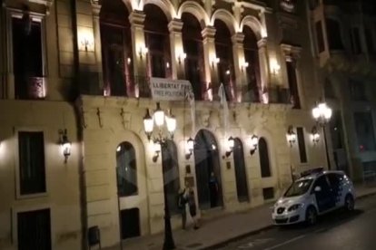 Tres homes arrenquen la pancarta de la Paeria en suport als polítics presos