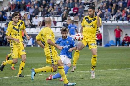 Fernando Cano és frenat per un defensa del Badalona dins de l’àrea, en una acció atacant del Lleida.