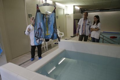 A l’esquerra, pacients fent ahir exercicis de rehabilitació i, a la dreta, una grua que permetrà ajudar usuaris a entrar a la piscina.