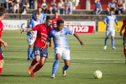 Liberto conduce el balón ante la presión de dos rivales.
