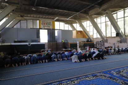 A l’esquerra, imatge del solar que acollirà la mesquita el setembre i l’octubre i, a la dreta, musulmans resant ahir al Palau de Vidre.