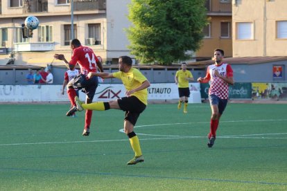 Buba Mballo, jugador del Balaguer, intenta controlar el balón ante la potencia física de Cheikh Saad, del EFAC Almacelles.