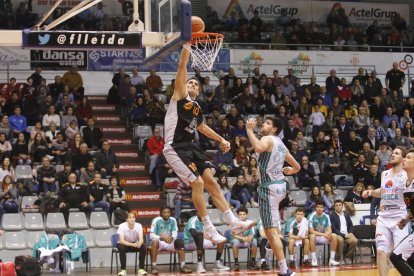 Ablaye Mbaye i Juampi Sutina lluiten per un rebot amb un jugador del Peñas Osca.