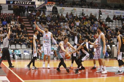 Ablaye Mbaye i Juampi Sutina lluiten per un rebot amb un jugador del Peñas Osca.