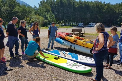 Un grup practica esports aquàtics a Gimenells i, a la imatge dreta, la vigilant de la zona de bany de Camarasa, que va començar a treballar ahir.