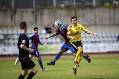 Dos jugadores del Mollerussa tratan de evitar que un adversario controle el balón.