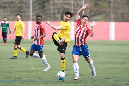 Un jugador de l’EFAC pugna amb un adversari pel control d’una pilota dividida.