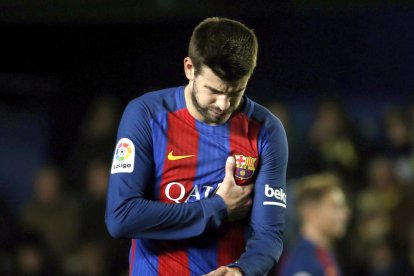 Piqué es lamenta després de rebre un cop al pit.