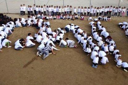 Alcarràs  -  La comunidad educativa de la Escola Parc del Saladar interpretó canciones y colgó unas cintas de colores en la valla con deseos de paz hechos por los niños y niñas de la escuela.