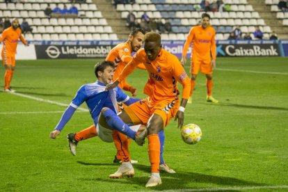 Joan Oriol centra el balón presionado por Carlos Barreda.