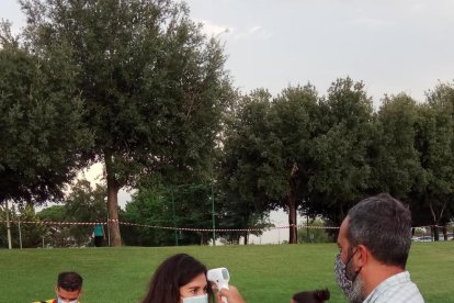 A dalt, entrenament amb grups reduïts i presa de temperatura. A baix, firma de declaració de responsabilitat i tècnics de l’staff.