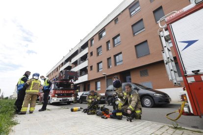 Momento en el que los bomberos sacaron a la mujer de la vivienda (i) y del amplio dispostivo desplegado (d).