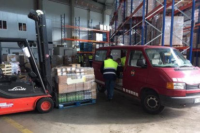 Voluntarios que ayer trabajaban preparando lotes de comida en el almacén central del Banc dels Aliments de Lleida.