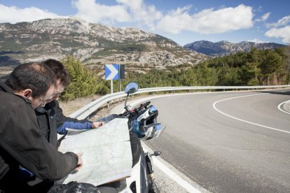 Motoristas pasando por el pantano de Rialb.