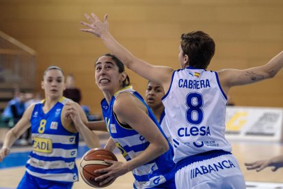 Andrea Vilaró penetra a canasta ante Shelby Cheslek, jugadora del Uni Ferrol.