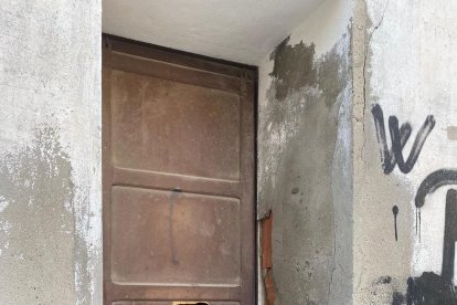 Dos jóvenes con taburetes del bar Rasep, cerrado, en La Granja d’Escarp.