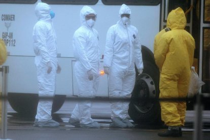 Un trabajador, con mascarilla, sale del recinto ferial de Gran Via, donde se iba a celebrar el Mobile.