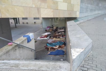 A l’esquerra, desenes de persones al porxo de la Casa de Fusta i, a la dreta, d’altres dormint al del Centre Cívic de l’Ereta.