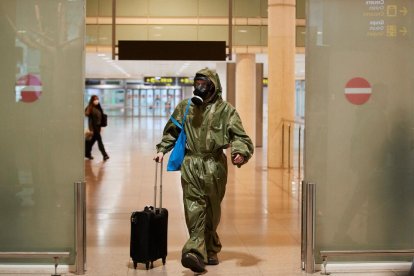 Un passatger procedent de Londres va arribar al Prat amb un vestit protector i màscara antigàs.