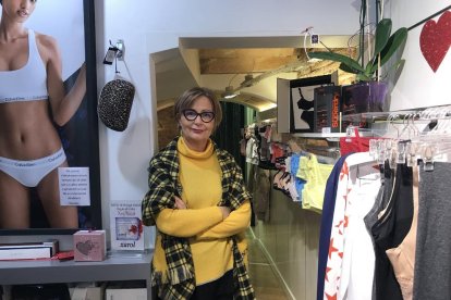 Una empleada de una óptica de Lleida enseña varias gafas a una clienta.