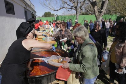 Els voluntaris reparteixen racions de la gran cassola que es va cuinar al parc del Graó.