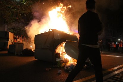 Un jove davant d’una de les barricades incendiades al centre de Barcelona.