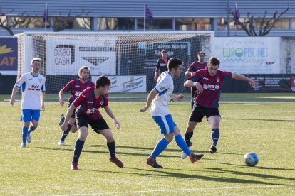 Dos jugadors es disputen el control de la pilota durant una acció del partit.